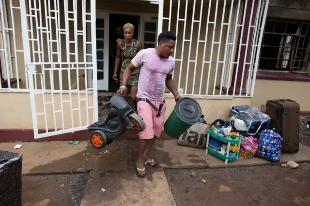 A Nigerian man gathers his belongings after his house was burned out by a vigilante mob in Pretoria, South Africa, 18 February 2017