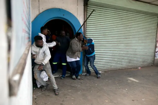 
          Nigerian migrants take cover during an attack by an angry mob outside a church in Pretoria, South Africa February 18, 2017. REUTERS
        