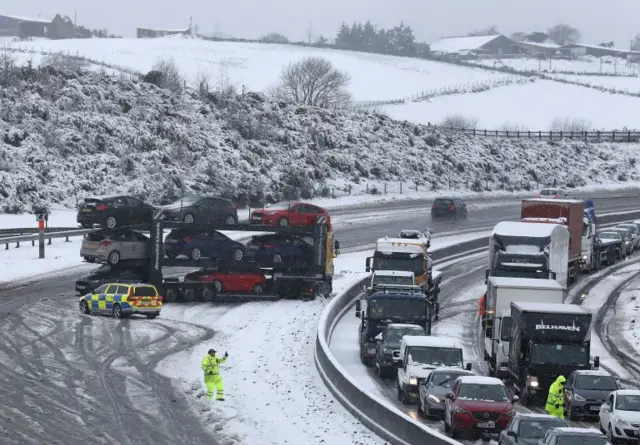 A jack-knifed car transporter blocks the M80 at Banknock after heavy snow fall