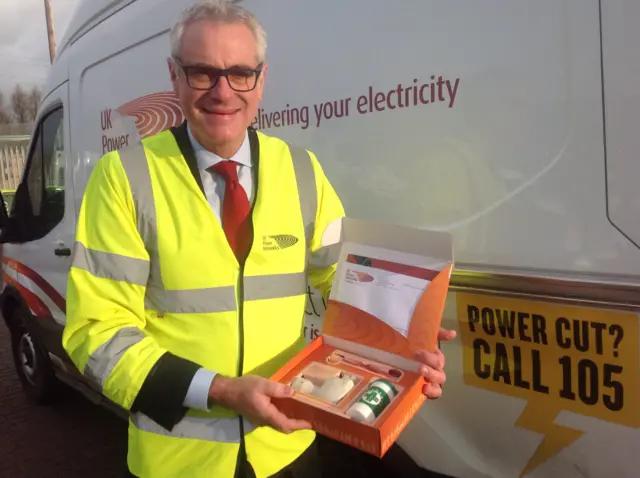 Matt Rudling holding a box of emergency power supplies for vulnerable people