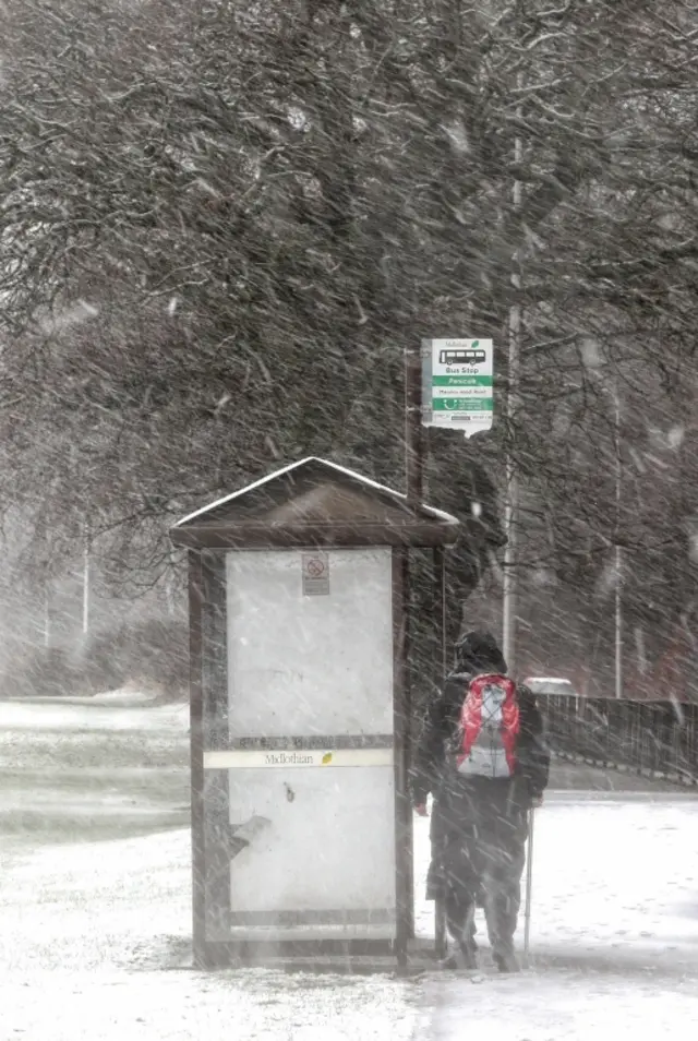 A man waits for a bus at Penicuik in Midlothian