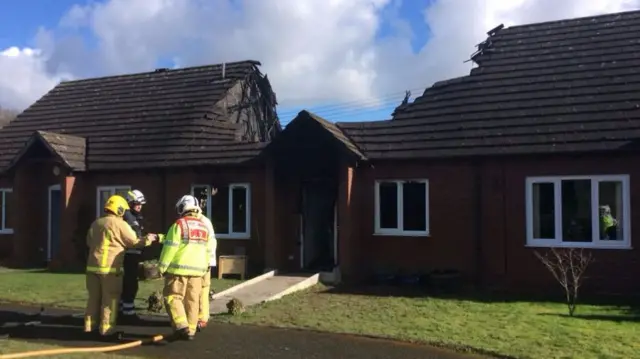 Firemen outside bungalows