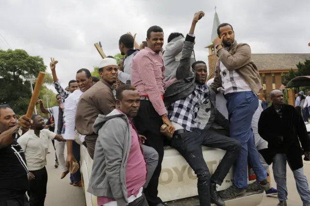 Somali migrants gesture at South Africans