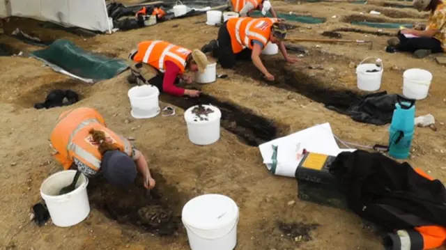 Archaeologists working on the coffins