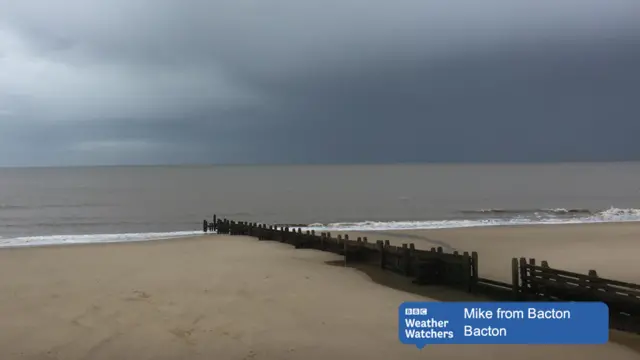 Deserted sandy beach, with dark stormy clouds overhead