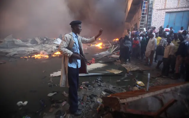 
          A Somali policeman controls residents gathered near the burning stalls at the main Bakara market in Somalia"s capital Mogadishu
        