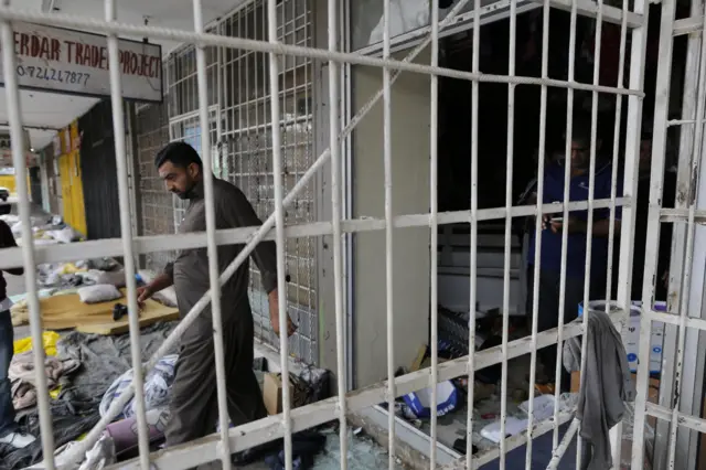 
          A Pakistani national inspects his shop after it was looted by South African residents during a xenophobic march
        