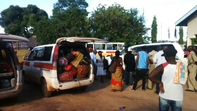 People pack their belongings in minibuses