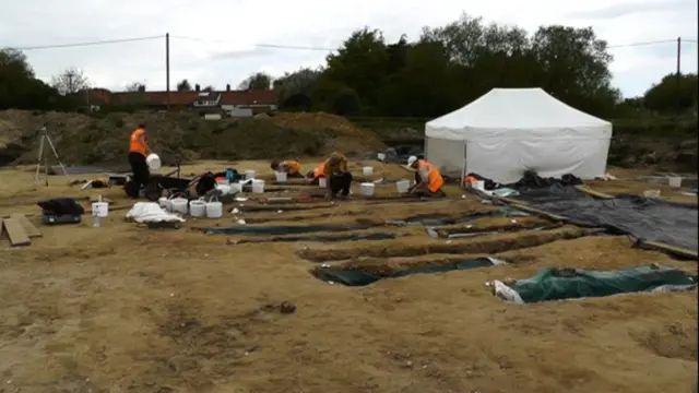 
          Archaeologists at work on the site of the 8th century cemetery, with uncovered coffins
        