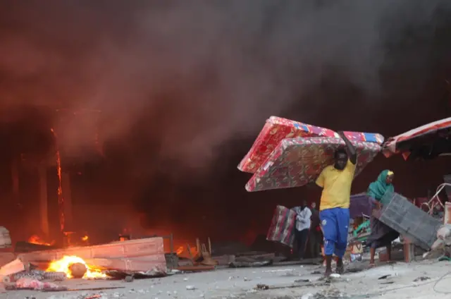 
          Somali traders salvage some of their wares from the burning stalls at the main Bakara market in Somalia"s capital Mogadishu
        