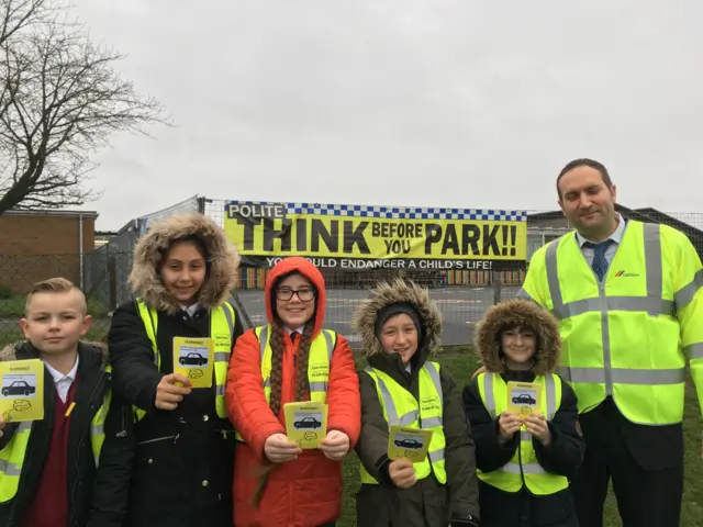 Five children dressed as parking wardens, holding tickets