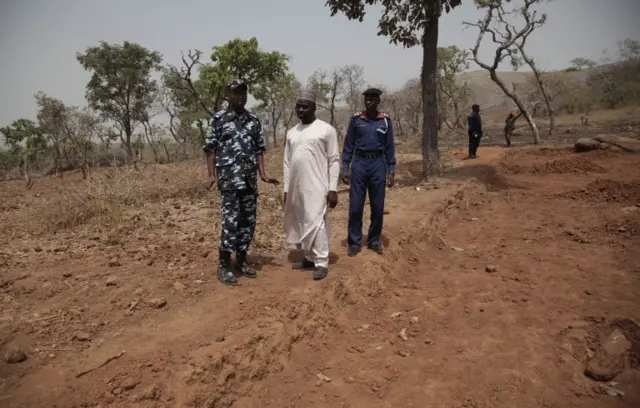 
          Security officers stand guard at the scene where a German archaeologists and his associate were kidnapped in Janjala Village, Nigeria
        