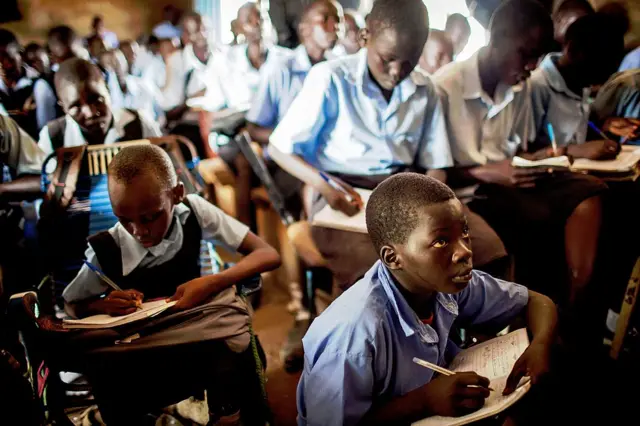 
          South Sudanese students sit at desks during an English lesson
        