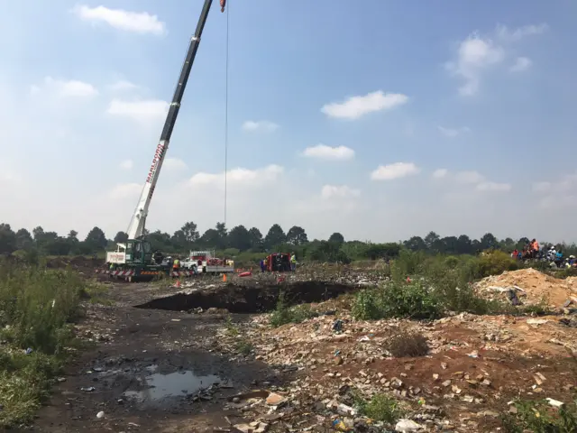 Open mineshaft visible with a crane next to it