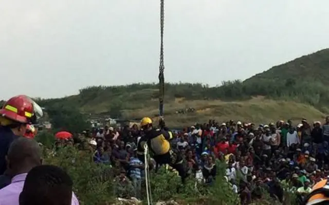 
          Community members look on as a rescue worker is sent underground to save a five-year-old boy fell into a disused mine shaft in Boksburg. Picture: Pelane Phakgadi/EWN
        