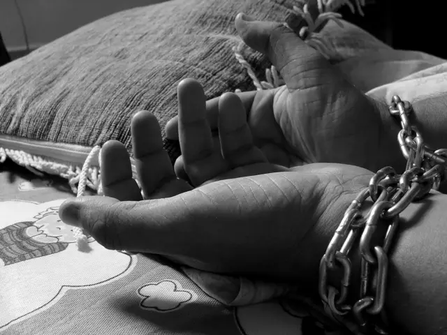 Image of woman's hands in chains