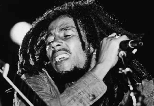 Jamaican reggae musician Bob Marley (1945 - 1981) performs on stage, a microphone in his hand, late 1970s