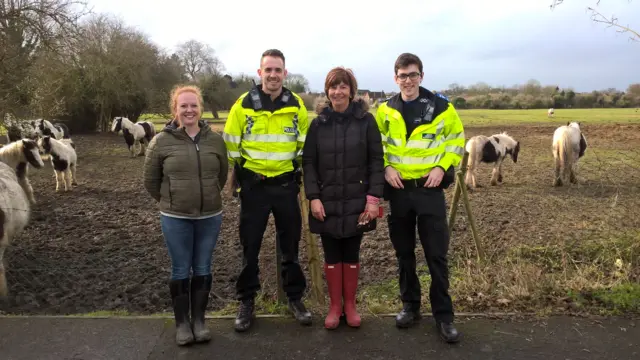 Police and residents by a field