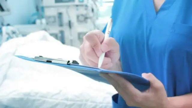 Nurse beside hospital bed