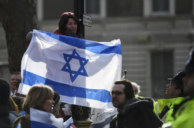 Demonstrator holding Israeli flag outside No 10