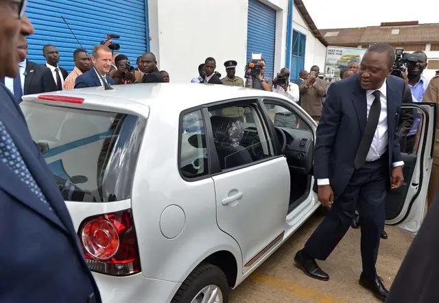 Kenyan President Uhuru Kenyatta (R) gets out a Polo Vivo after testing it with Volkswagen Brand CEO Herbert Diess (L) at the newly opened assembly line of the Volkswagen model at Kenya's Thika town industrial area, on December 21, 2016.