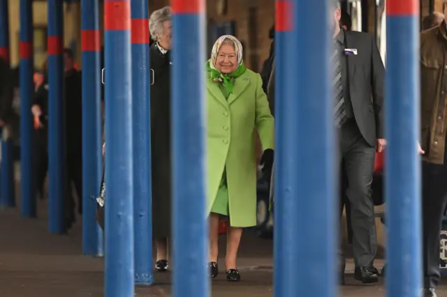 The Queen, in lime green coat and decorated head scarf, at King's Lynn station