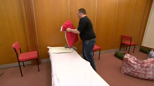 One Roof charity worker making up a bed