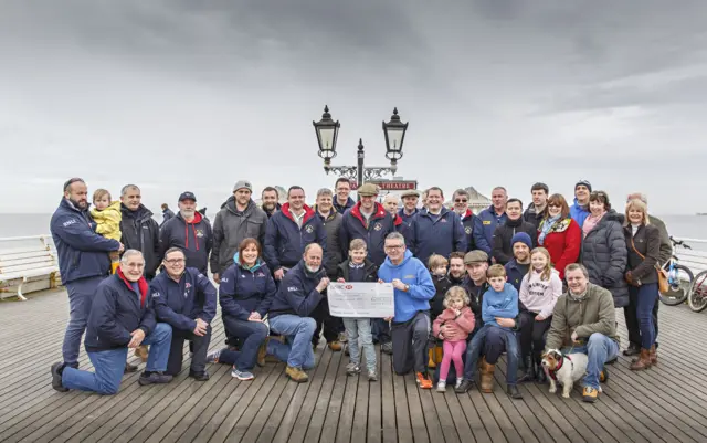 Cromer lifeboat crew receive cheque from North Norfolk Beach Runners