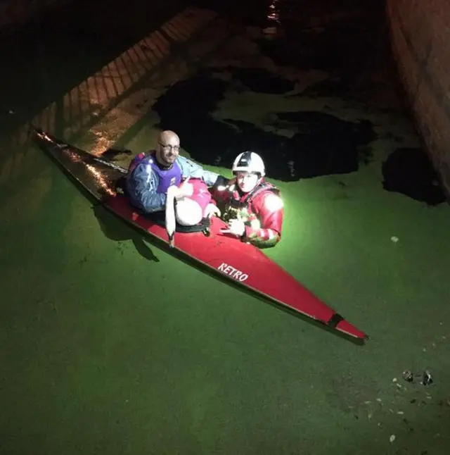 Swan being rescued from canal