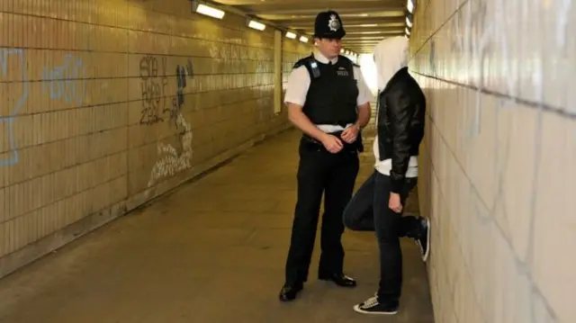 Officer talks to hooded person