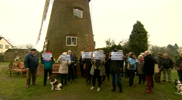 Protesters underneath the windmill