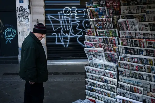 Greek man looks at newspaper headlines at a kiosk in Athens