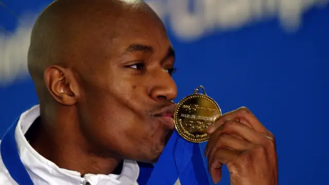 Marlon Devonish kissing his gold medal in 2003