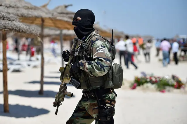 
          Armed guards patrol Marhaba beach during a visit by British Home Secretary Theresa May at the scene where 38 people were killed on Marhaba beach last Friday, on June 29, Sousse, Tunisia
        