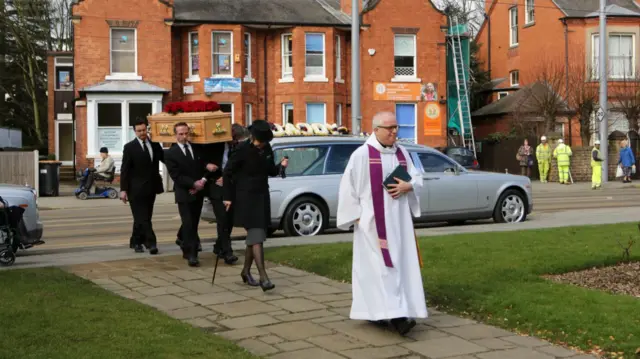 Funeral party heads into chuch