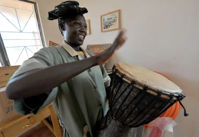 
          Mrs Ouedraogo, president of the Women's Centre for Plastic Recycling, hits a Djembe made of plastic ahead of taking a literacy class held at the rubbish dump of Ougadougou.
        