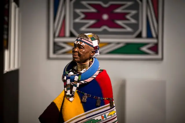 
          South African artist Esther Mahlangu, 81, examines an exhibition of her artwork inspired by Nelson Mandela on March 1, 2017 at the Melrose Gallery in Johannesburg
        