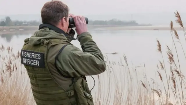 Fisheries Officer with binoculars