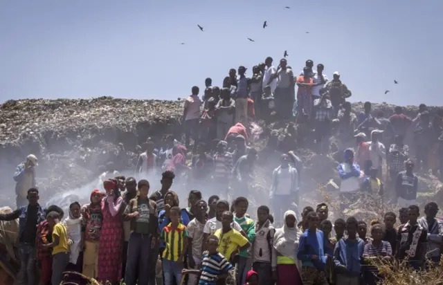 
          In this Sunday, March 12, 2017 photo, residents look on as rescue efforts take place at the scene of a garbage landslide, on the outskirts of the capital Addis Ababa, in Ethiopia
        