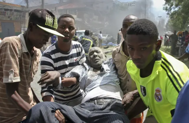 
          Rescuers carry away a man who was wounded in a car bomb attack in Mogadishu, Somalia Monday, March 13, 2017
        