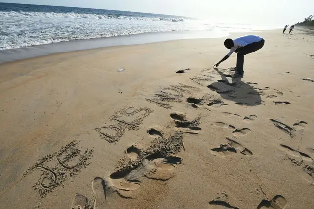 
          Man writes "I say no to terrorism" in French in the sand at scene of the attack, in 2016.
        