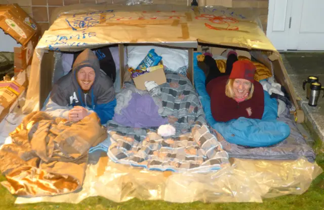 People sleeping in cardboard shelter