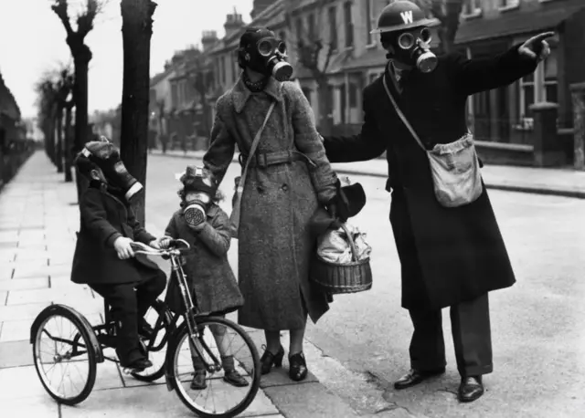 
          March 1941: A warden gives directions to a mother and her two children during a World War II gas drill in Southend
        