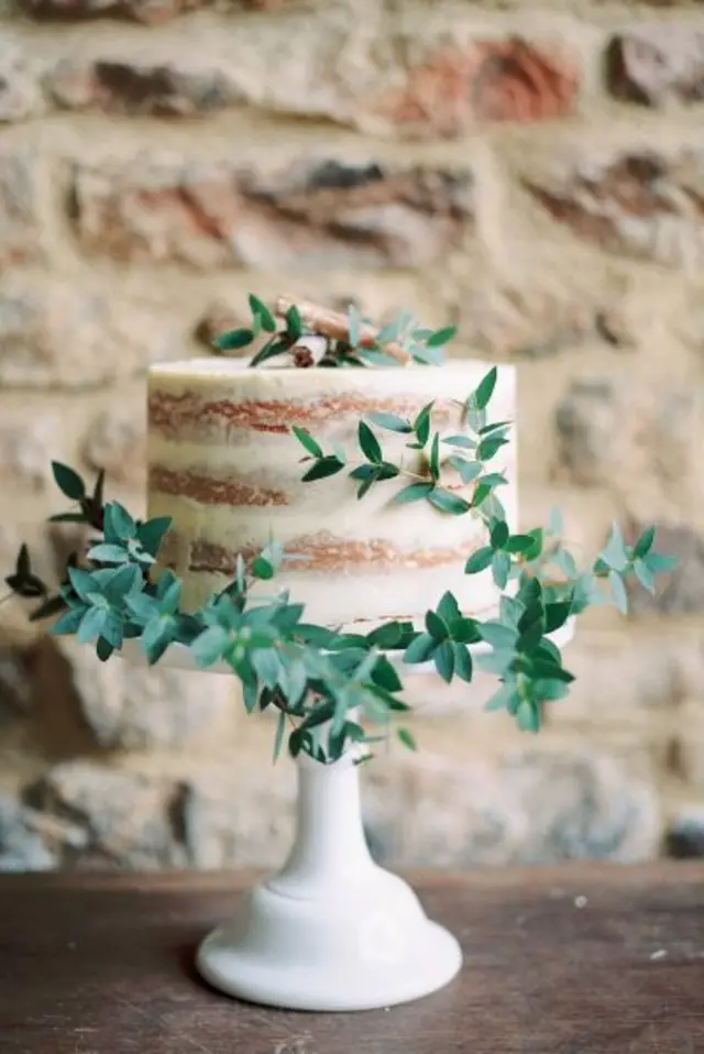 A cake with cream icing and decorative leaves