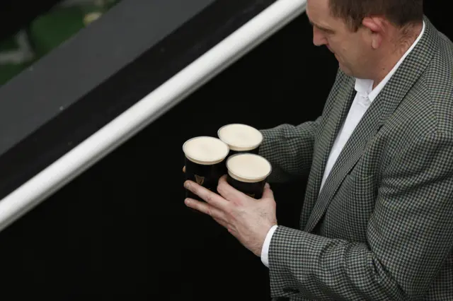 A man carries pints of guiness