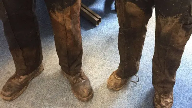 
          Police officers reveal dirty trousers after chase through swampy fields
        