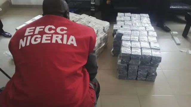 An official looks at bundles of cash