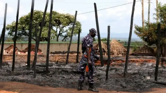 A Ugandan soldier looks at rubble