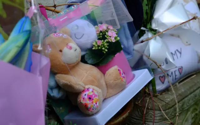 Tributes and teddy bear left outside the family's home