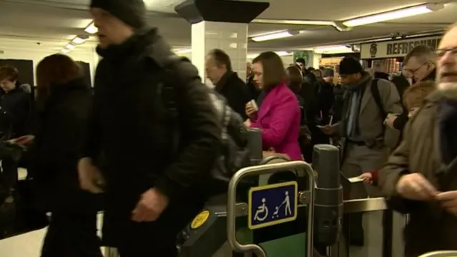 Rail passengers going through turnstiles